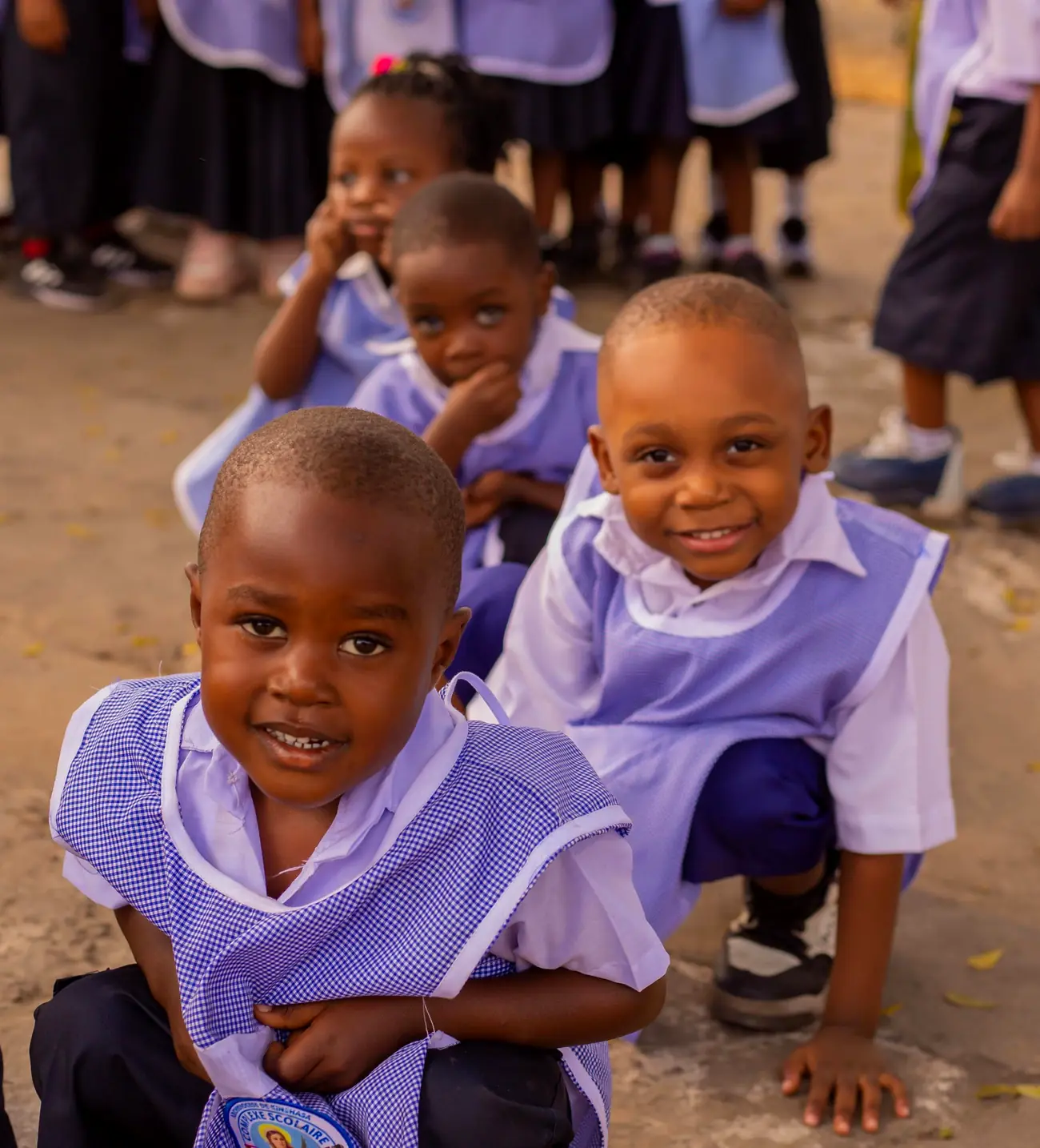 Deux enfants de la maternelle Sainte Lucie, souriants, en tablier lilas